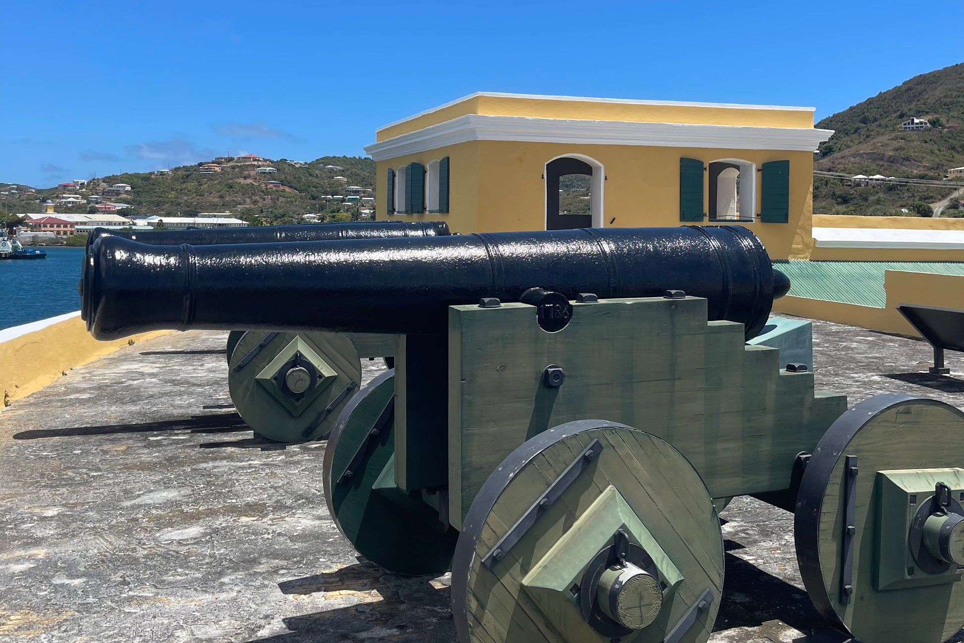 Fort Christiansvaern, St.Croix, USVI. Green and Black Canon in front of a yellow fort.