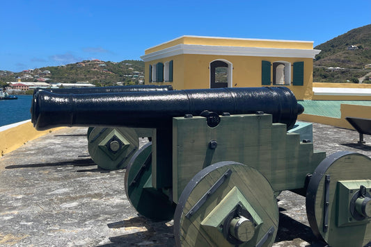 Fort Christiansvaern, St.Croix, USVI. Green and Black Canon in front of a yellow fort.